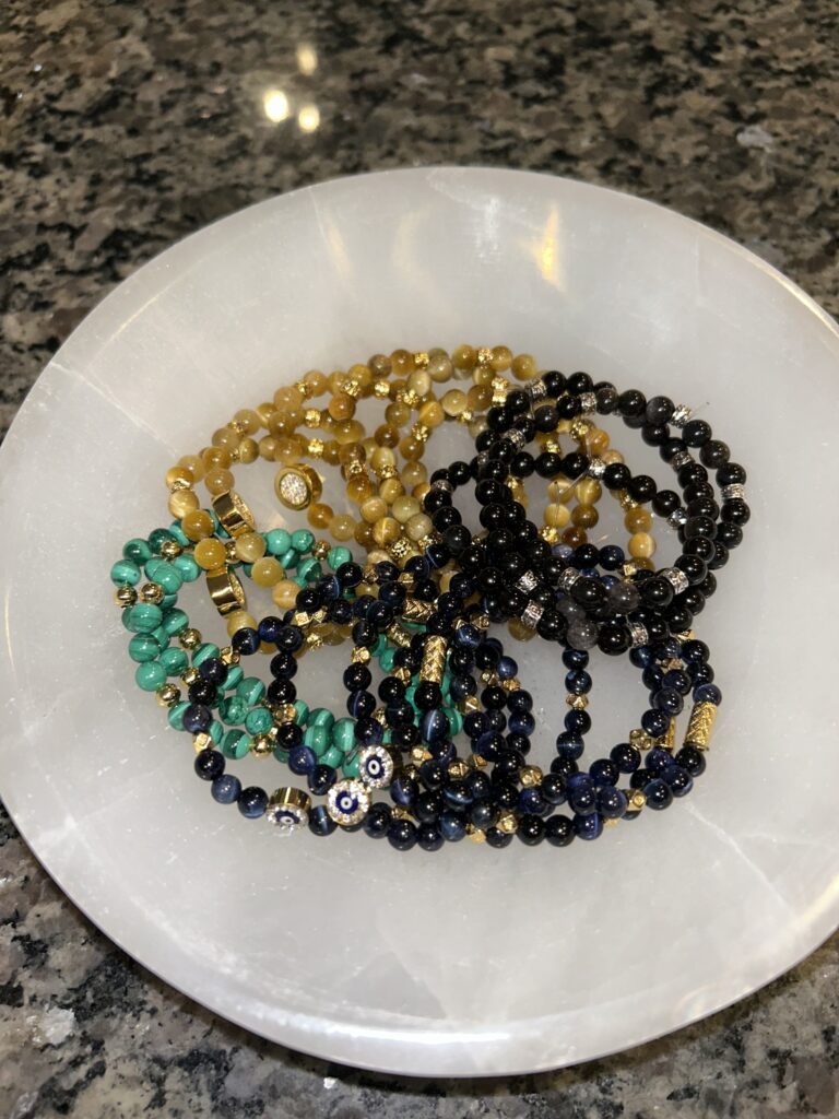 Collection of Gem Bracelets on A Plate Green Black and Yellow from the top